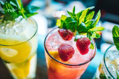 Yenilenmiş ve egzotik alkolik Mojito kokteylleri. Barda naneli, çilekli ve çilekli kokteyller. Bu yaz alkolsüz içecek egzotik renkli kokteyl..