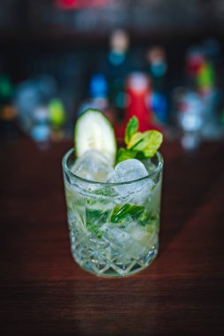 Bar masasında salatalıklı cin kokteyli. Bu yaz egzotik renkli bir kokteyl.