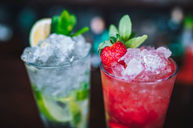 Yenilenmiş ve egzotik alkolik Mojito kokteylleri. Barda naneli, çilekli ve çilekli kokteyller. Bu yaz alkolsüz içecek egzotik renkli kokteyl..