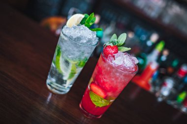 Yenilenmiş ve egzotik alkolik Mojito kokteylleri. Barda naneli, çilekli ve çilekli kokteyller. Bu yaz alkolsüz içecek egzotik renkli kokteyl..