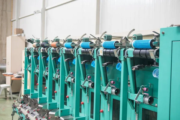 Group of bobbin thread cones on a warping machine in a textile mill. Yarn ball making in a textile factory. Textile industry - yarn spools on spinning machine in a textile factory