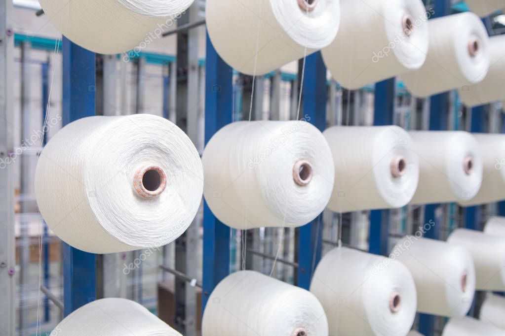 Group of bobbin thread cones on a warping machine in a textile mill. Yarn ball making in a textile factory. Textile industry - yarn spools on spinning machine in a textile factory