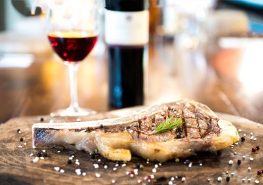 Restoranda şarap eşliğinde romantik bir akşam yemeği. Izgara lezzetli, dikey kuzu pirzola ve bir bardak şarap ve tahta tahta bir masa ve kırsal ahşap bir masa.