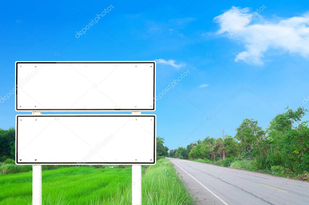 road with blank white road sign pole on blue sky with few clouds and green nature background, Clipping path