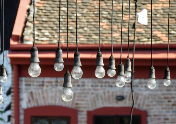 Hanging light bulbs in terrace of abandoned caffe.