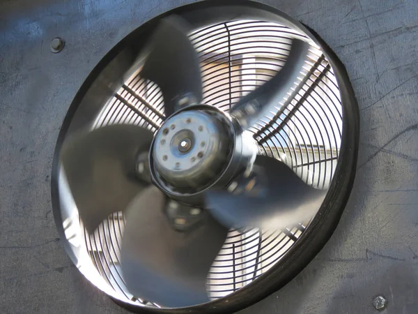 Rotating metal industrial fan on the building.