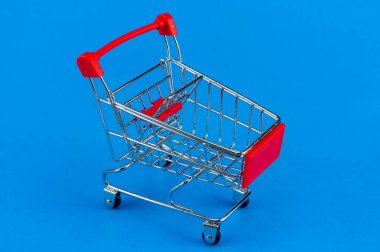 Alışveriş arabası üzerinde mavi arka plan izole.