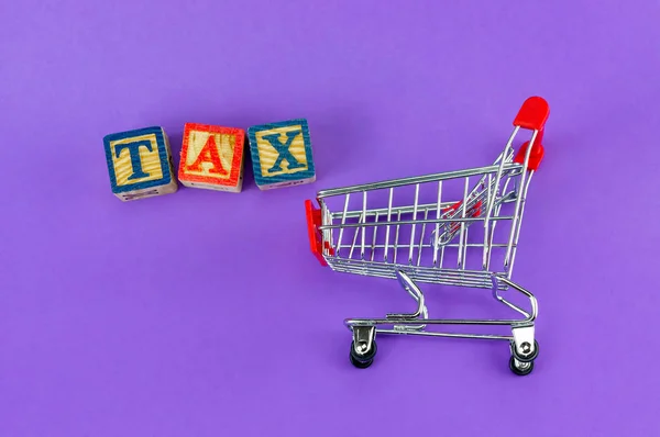 課税世帯の商品コンセプトに 紫色の背景にアルファベット ブロック トロリー — ストック写真