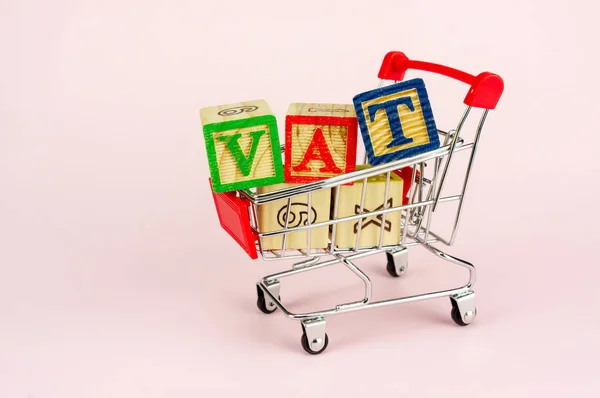 VAT (Value-Added Tax) on household goods concept. Trolley with alphabet (V.A.T) block.