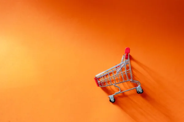 Vista Superior Del Carro Compra Sobre Fondo Naranja Con Espacio Fotos de stock libres de derechos