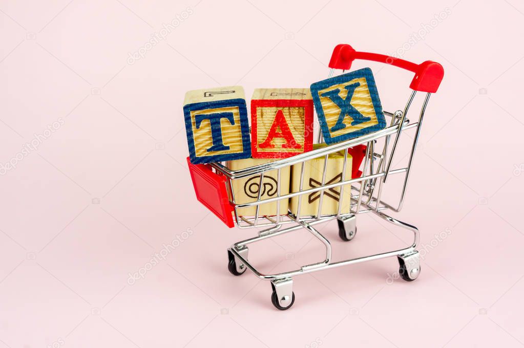 TAX and Taxation on household goods concept. Trolley with alphabet (T.A.X) block.