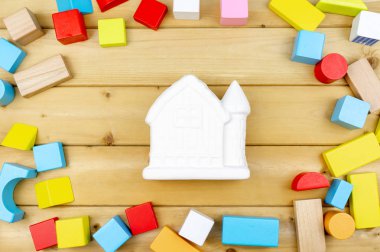 Seramik ev modeli ahşap küp oyuncaklar sarı ahşap plakalar zemin üzerine kapatın. Okul öncesi, eğitim ve boşluk kavramı veya diğer içerik.