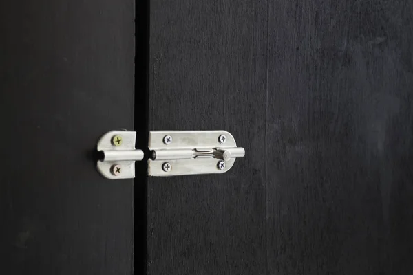Cerradura de puerta de acero atornillada sobre fondo negro — Foto de Stock