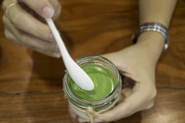 Mão na sobremesa de mousse de chá verde matcha — Fotografia de Stock