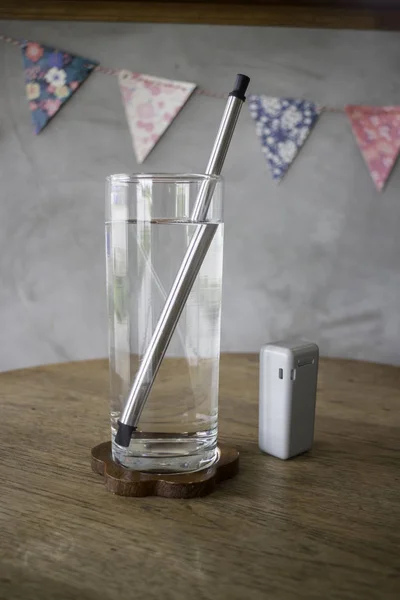 Reusable metal drinking straw in glass of water — Stock Photo, Image