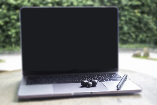 Computador portátil moderno na mesa de madeira no jardim home — Fotografia de Stock