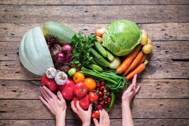 Sağlık Bakımı ürün yelpazesine taze organik sebze kalp şekli ahşap arka plan ülke stil kadın çocuk elele tutuşun. Pazar kavramı yerel Bahçe üretmek temiz yemek yeme Diyet