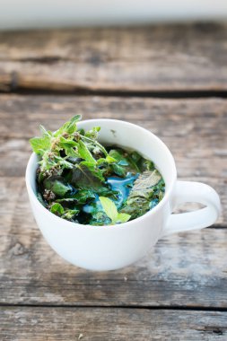Bitkisel yeşil nane çayı üzerinde ahşap arka plan sağlıklı bevarage beyaz Kupası