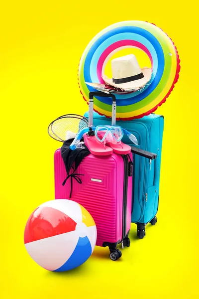 Bright Suitcases Summer Accessories Things Slippers Hat Mask Ballon Rackets. Concept Summer Holiday Travel Family Trip Background Isolated Yellow