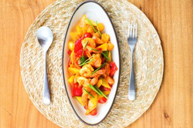 Tatlı ve ekşi soslu kızarmış karides stir, Tay yemekleri nasıl çatal spoonstraw peçete ahşap masa üstten görünüm