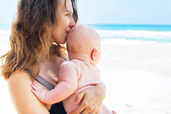 母を保持赤ちゃん手水分保全サイン太陽皮膚をやさしく肩幼児晴れた日で休暇海海岸保護化粧品クリーム — ストック写真