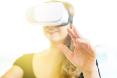 Arka plan sanal gerçeklik gözlükleri ile Smartphone kullanarak VR gözlük kask seçici odak üstünde el giyen genç kadın bulanık