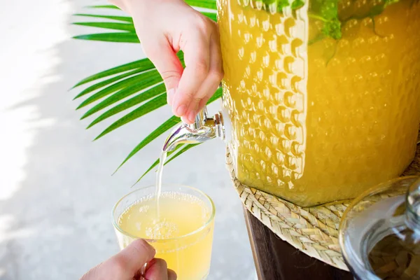 Kid hands opening tap Jar homemade lemonade with fresh lemon sliced leaves mint Ice cold useful juicy beverage in hot weather Refreshing drink Summer time