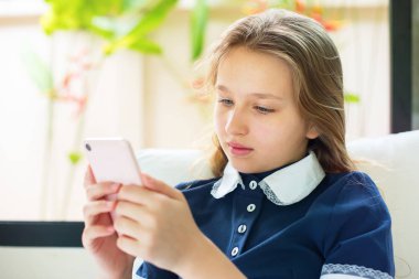 Güzel genç kavramı ücretsiz okul eğitim evde koltukta oturan smartphone içinde arıyorum