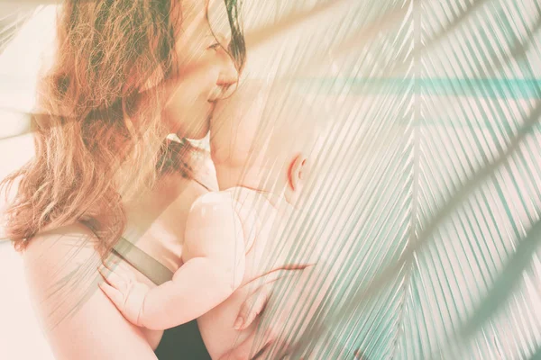 Mamma håller baby på händerna skyddande fukt — Stockfoto