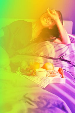 Yatakta kahvaltı. Genç güzel kadın gülüyor