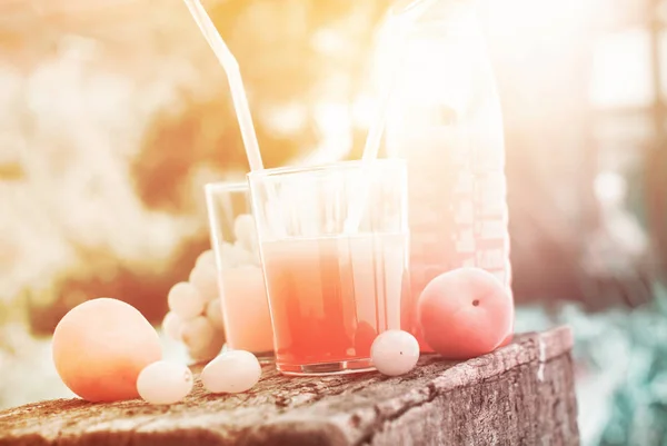 Meyve ve ahşap masa üzerinde taze meyve suyu gazlar — Stok fotoğraf