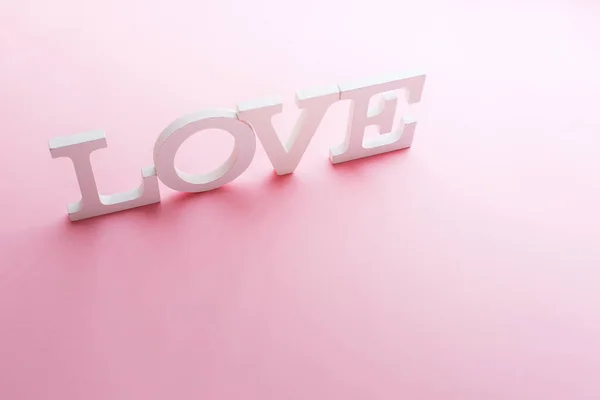 Word love white volume letters on pink background