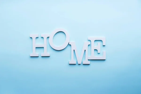 Слово додому білі літери гучності на синьому фоні — стокове фото
