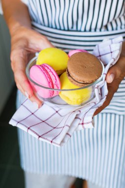 Renkli Fransızca macaroons Kupası tutan eller
