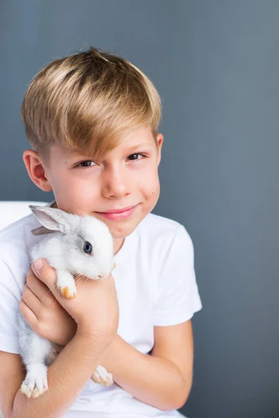 Pequeño niño blanco camiseta y conejo enano domesticado — Foto de Stock