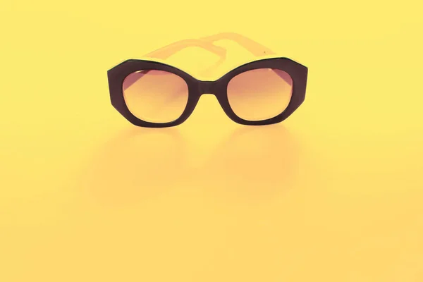 Kvinnans solglasögon Yellowbackground platt singel — Stockfoto