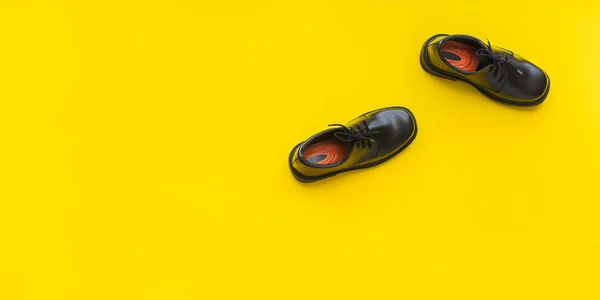 Siyah deri ayakkabı sarı arka plan üst görünümü — Stok fotoğraf