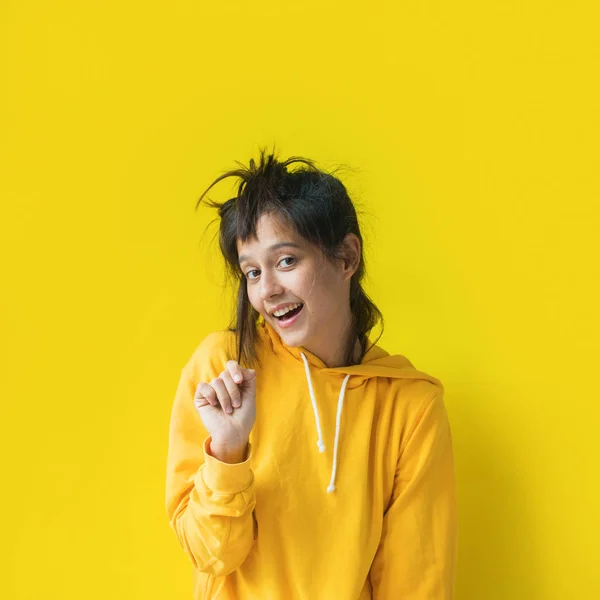 Lustige Mädchen mit gelber Kapuze Sweatshirt-Pose emotional — Stockfoto