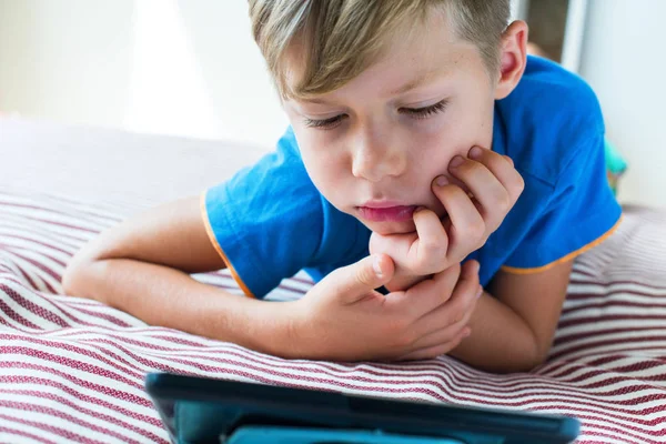 Nahaufnahme Porträt eines Schönhaarkindes beim Tablet-Gucken — Stockfoto