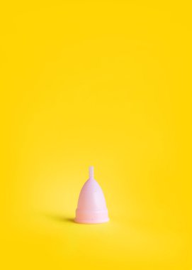 Sarı arka planda elinde pembe adet fincan