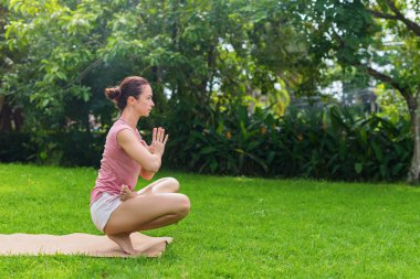 Doğal çayırda açık havada yoga yapan kız