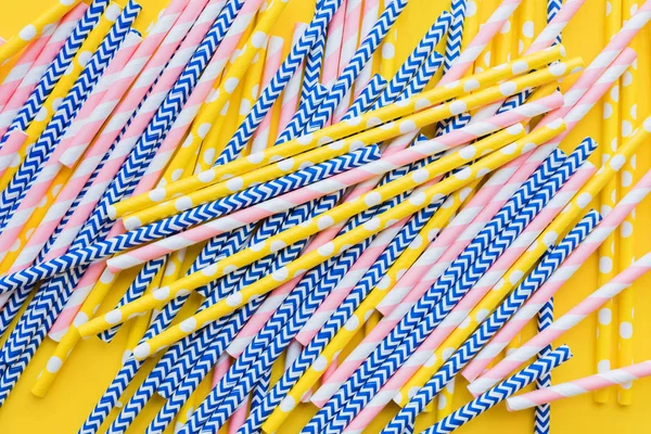 Striped, dotted paper straws scattered Flat lay