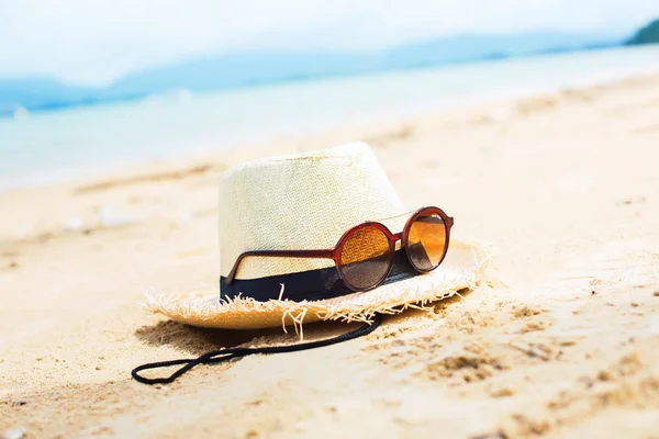 Sunglasses with reflection palms straw hat beach — Stock Photo, Image