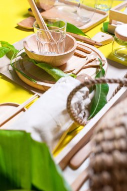 Sıfır atık. Organik ahşap mutfak aksesuarları, doğal yapraklar, bambu kamışları. Sağlıklı ekolojik ürünler. Parlak sarı arkaplan