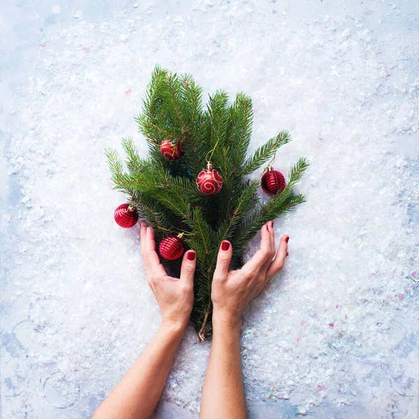 Mãos Femininas Segurando Festivo Natal Verde Ramos Abeto Com Bolas — Fotografia de Stock