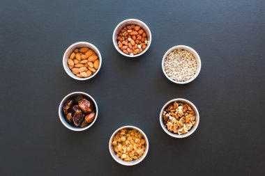 Yuvarlak Çerçeve Sağlıklı Çerez Fıstık Bademcikleri Ayçiçeği Tohumu Ayçiçeği Cevizi Üzümlü Küçük Bardaklar Üst Görünüm Kara Tahta Arka plan Sağlıklı Kavram Çemberi