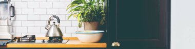 Siyah ahşap kapılı modern ev mutfağı. Boşluğu kopyala. Çaydanlık gazda