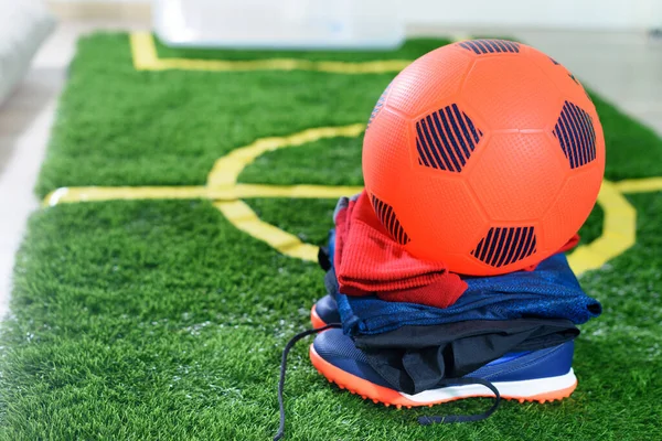 Oranje Voetbal Bovenop Uniform Schoenen Groen Veld Voor Kinderen Thuis — Stockfoto