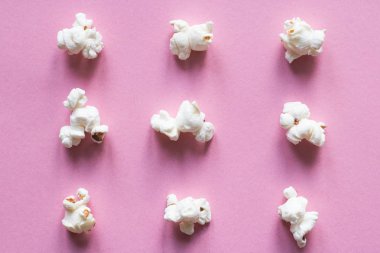 Pastel pembe üzerinde patlamış mısır. Atıştırmalık.