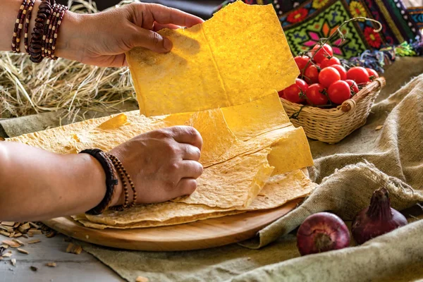 brown hands in bracelets hold pita bread